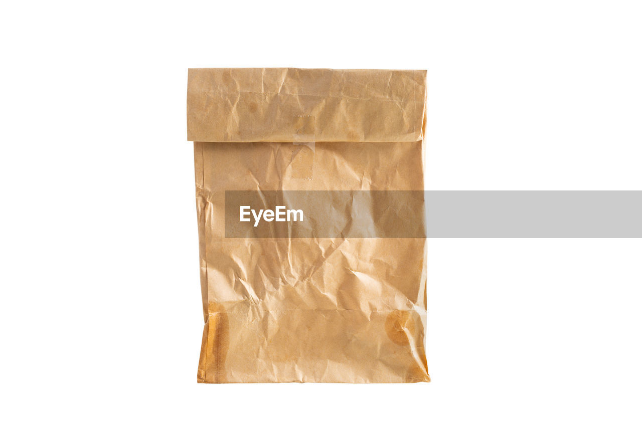 High angle view of crumpled paper bag against white background