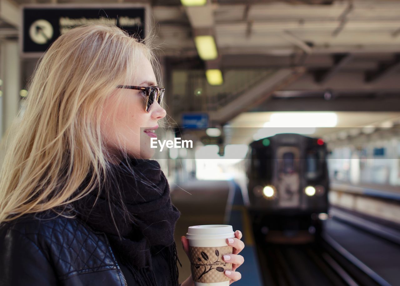 Woman holding coffee cup in city