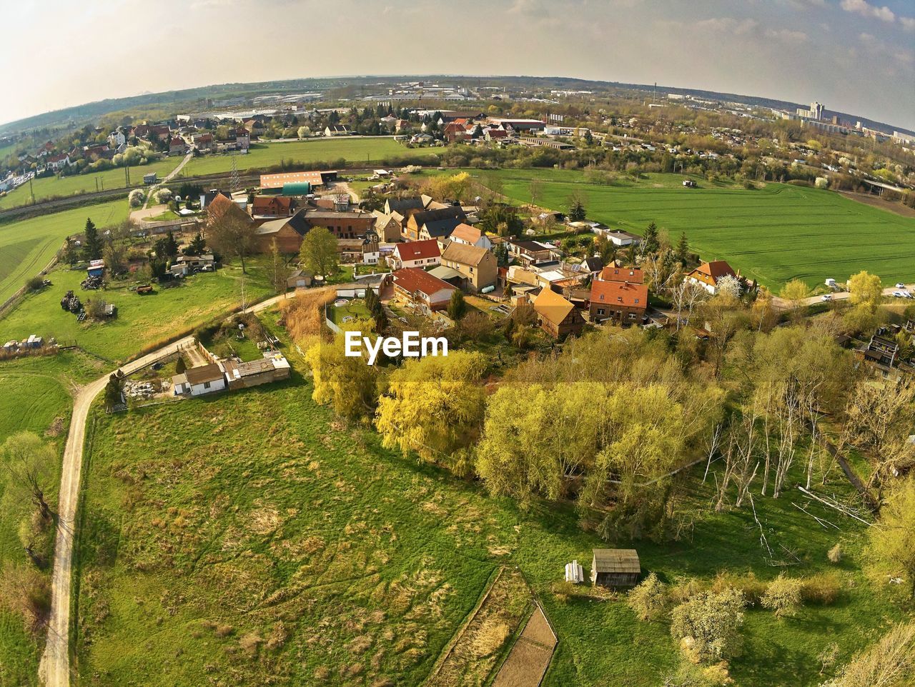 HIGH ANGLE VIEW OF TOWNSCAPE ON FIELD AGAINST SKY