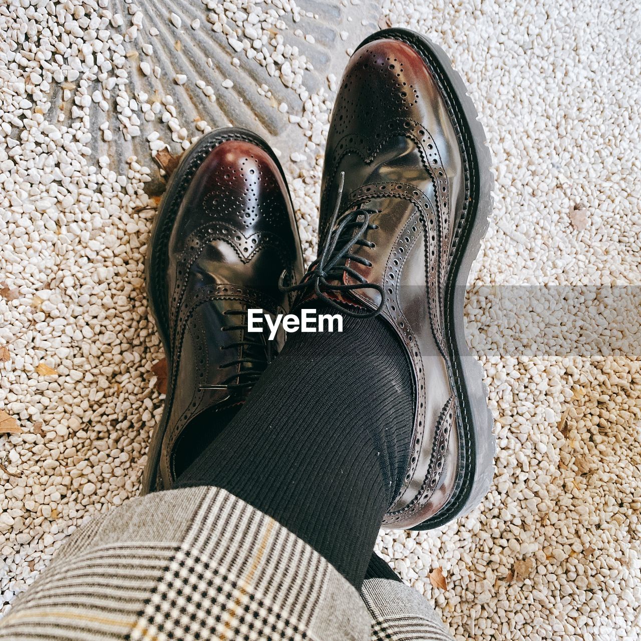 LOW SECTION OF PERSON WEARING CANVAS SHOES STANDING ON FLOOR