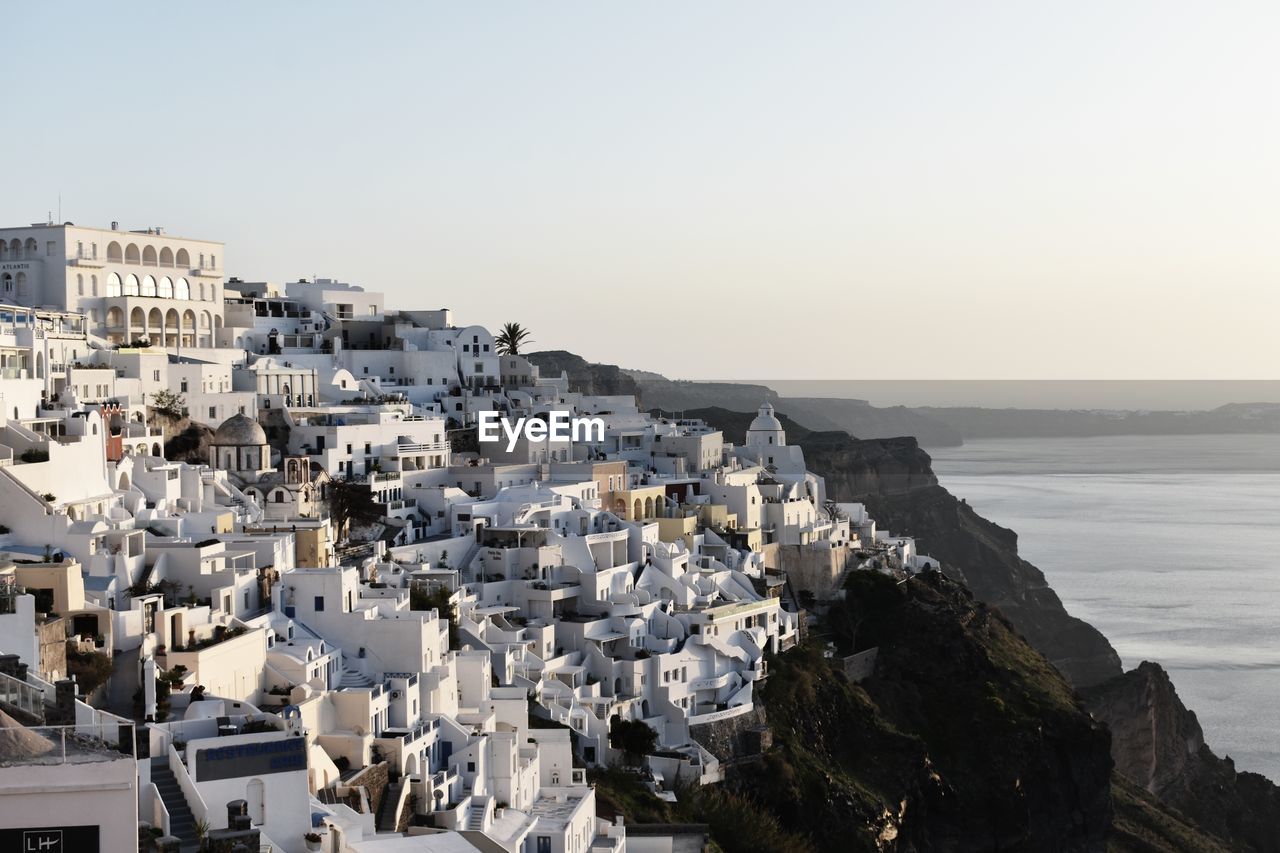 AERIAL VIEW OF BUILDINGS BY SEA AGAINST CLEAR SKY