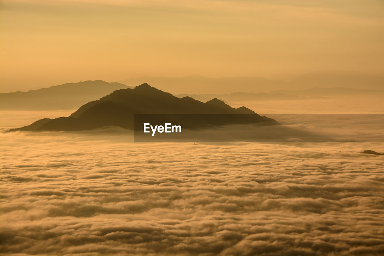 Scenic view of sea and mountains against dramatic sky