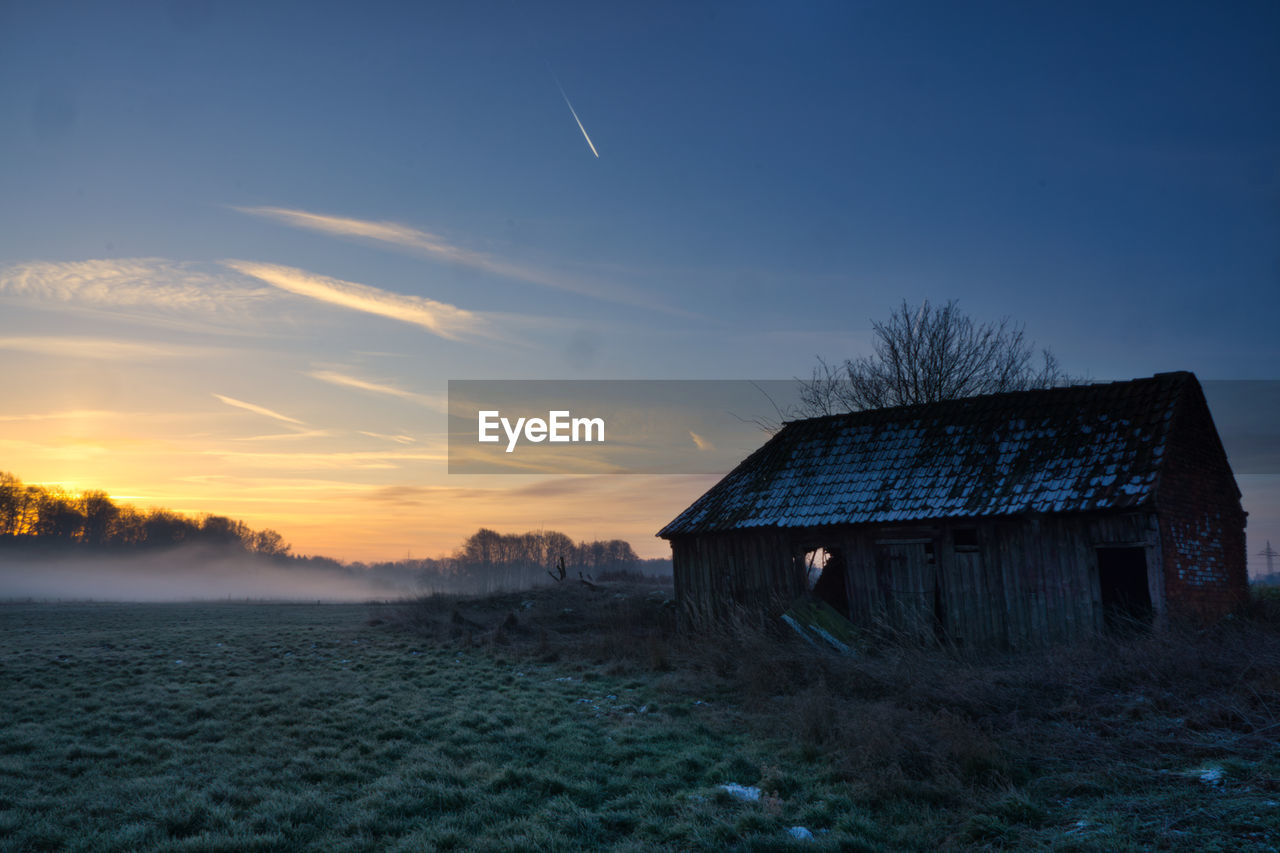 ABANDONED HOUSE ON FIELD AGAINST SKY