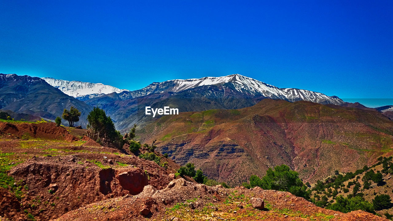 Scenic view of mountains against clear blue sky