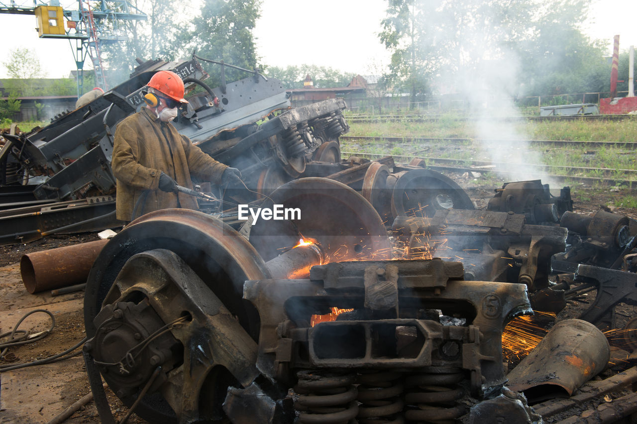 Welder welding scrap metal of train