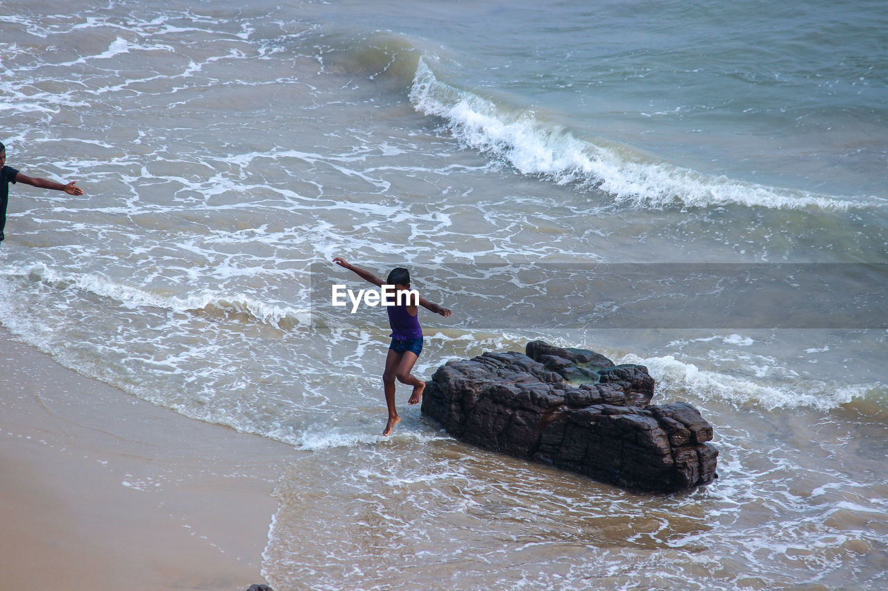 High angle view of boy jumping on beach