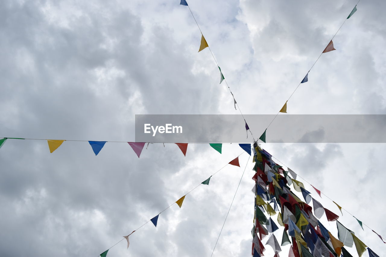 Low angle view of colorful buntings hanging against sky