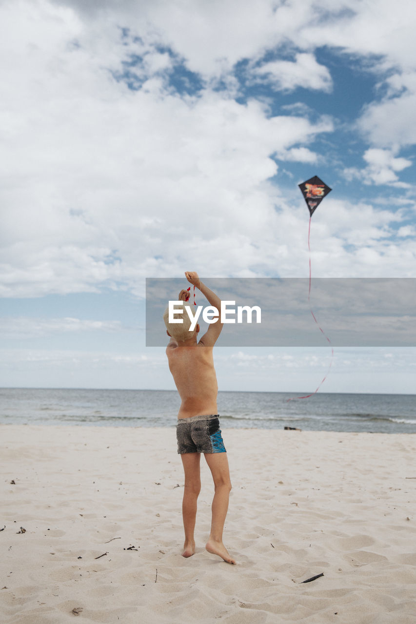 Boy on beach playing with kite