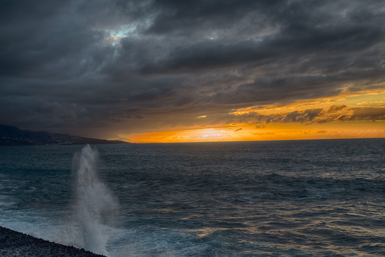 Dark dramatic sky over sea at sunset