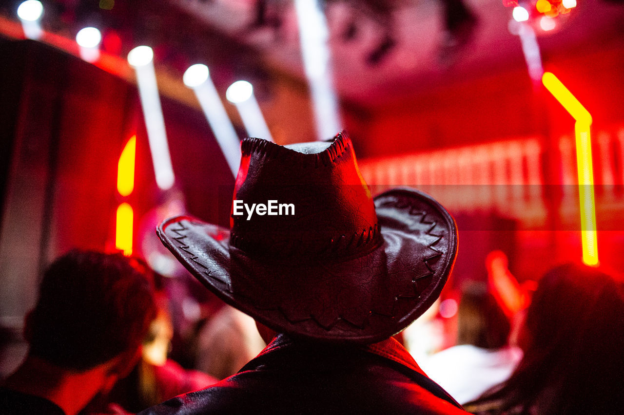 Rear view of man wearing cowboy hat at nightclub