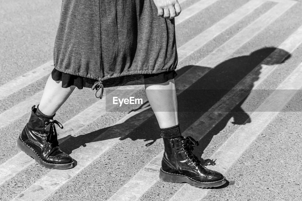 Low section of woman walking on crosswalk