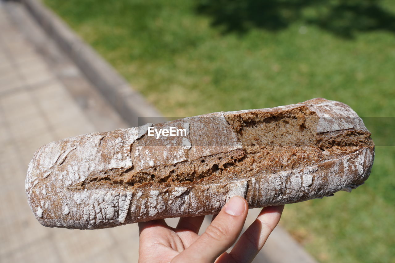 CLOSE-UP OF HAND HOLDING CHOCOLATE CAKE