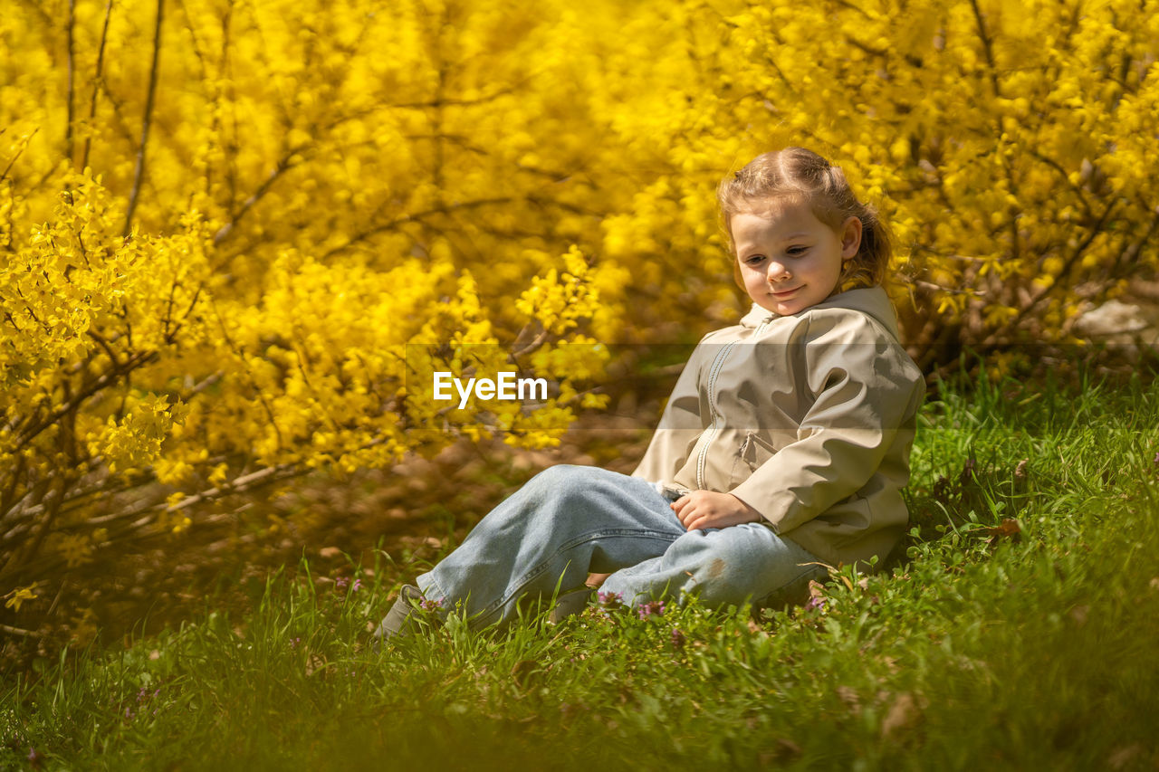 portrait of young woman standing on grassy field during autumn