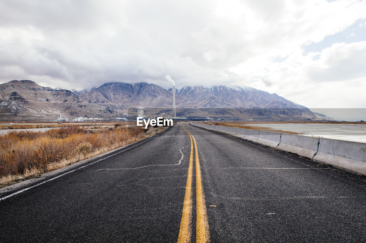 Empty road along countryside landscape