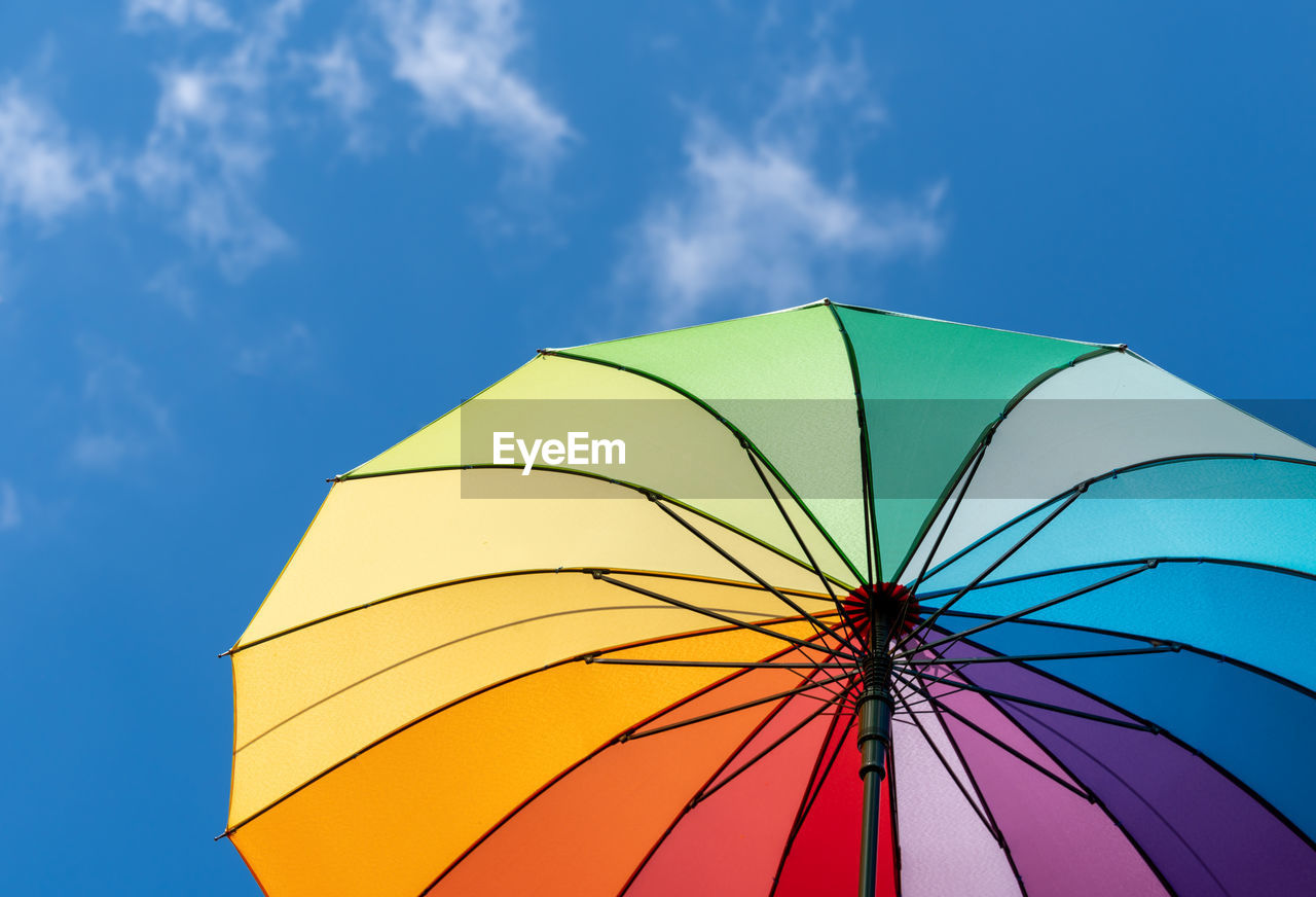 umbrella, protection, sky, fashion accessory, security, multi colored, blue, cloud, nature, low angle view, parasol, yellow, outdoors, vibrant color, no people, environment, rain, day, sunshade, summer