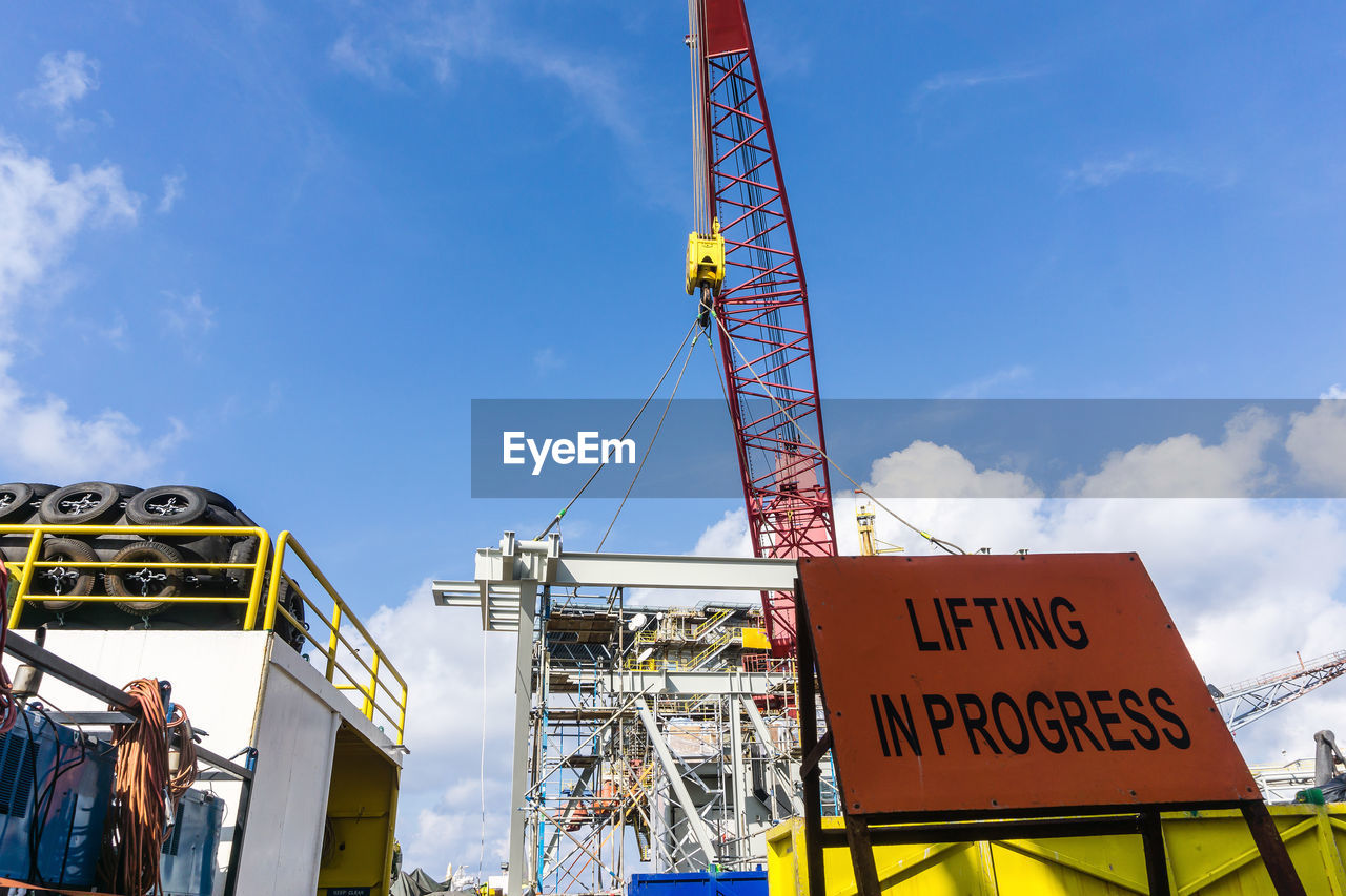 LOW ANGLE VIEW OF CRANE AGAINST SKY AT DUSK