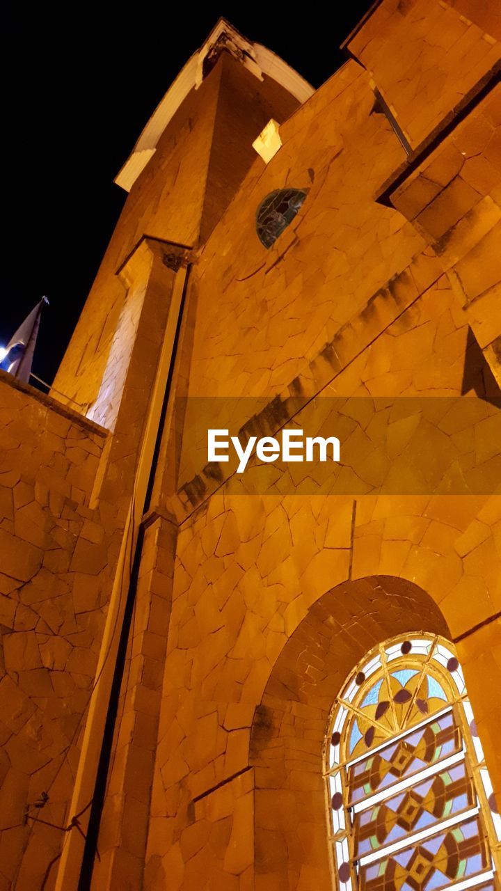 LOW ANGLE VIEW OF YELLOW AND BUILDING AT NIGHT