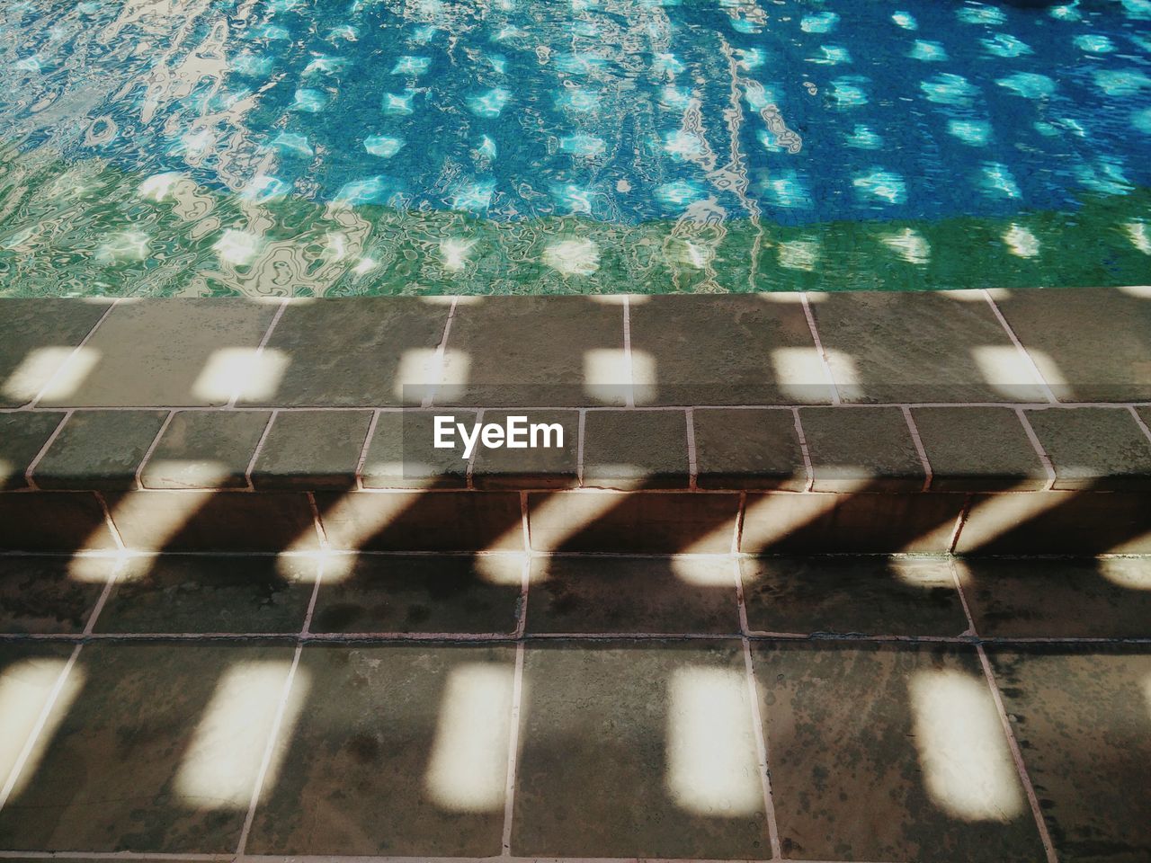 High angle view of sunlight falling on poolside