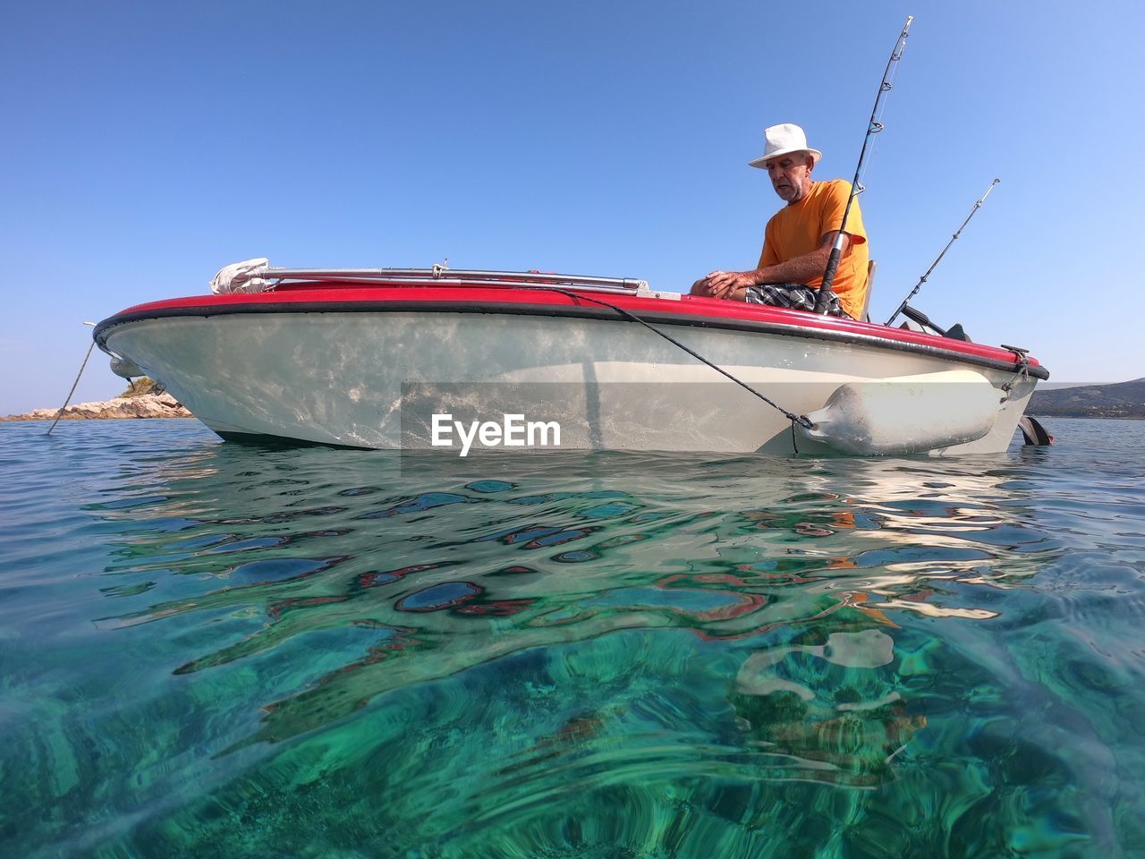 Portrait of senior man on a boat with clear sea and blue sky in background