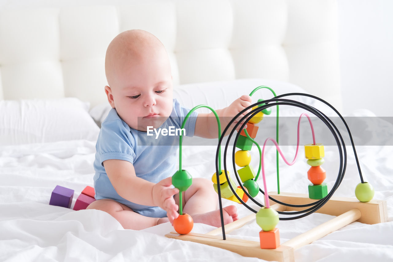 portrait of cute baby boy playing with toy blocks
