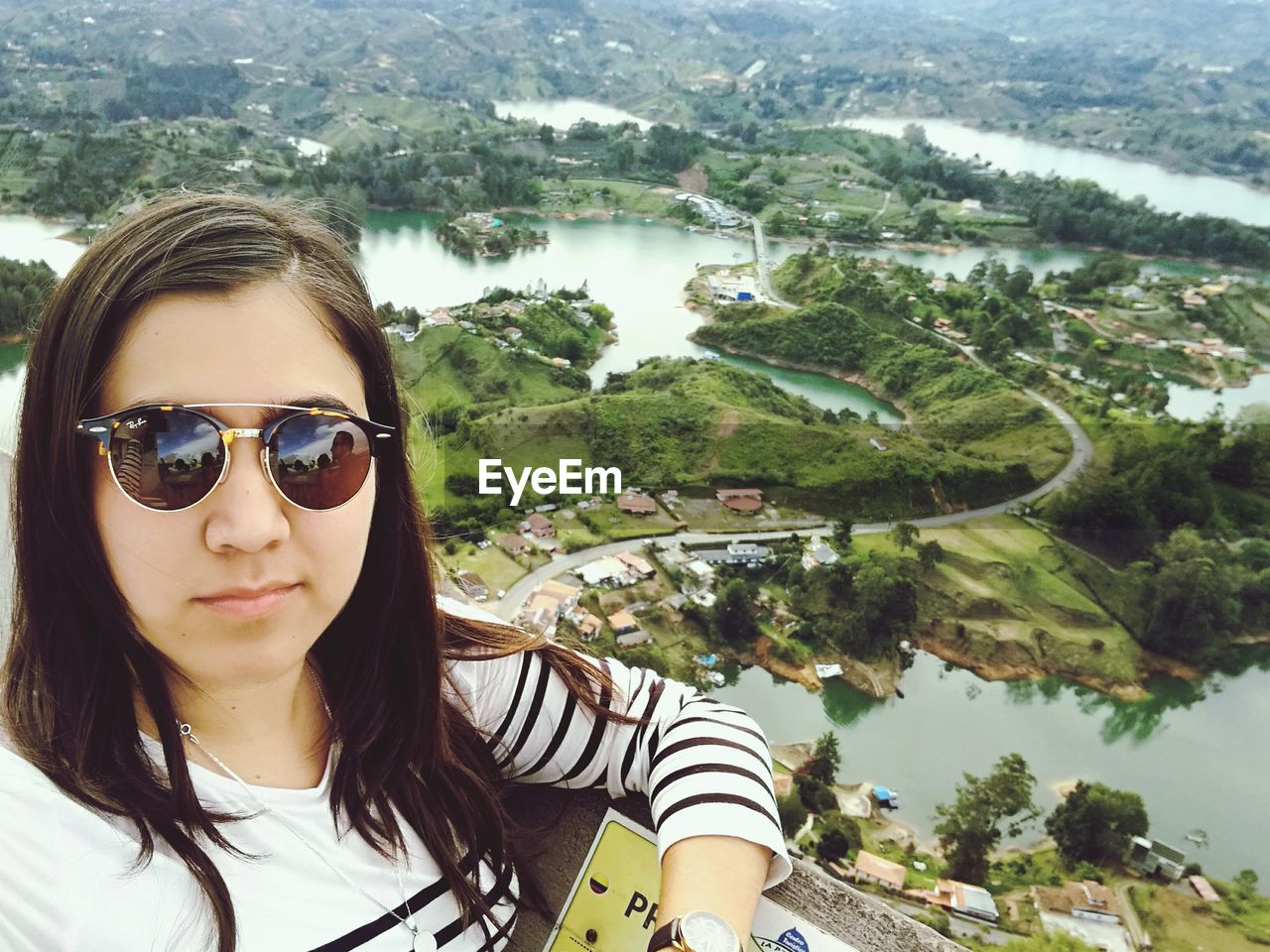 High angle portrait of woman wearing sunglasses against landscape
