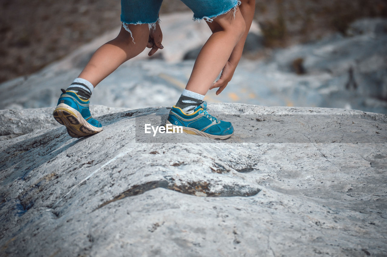 Low section of boy walking on rock