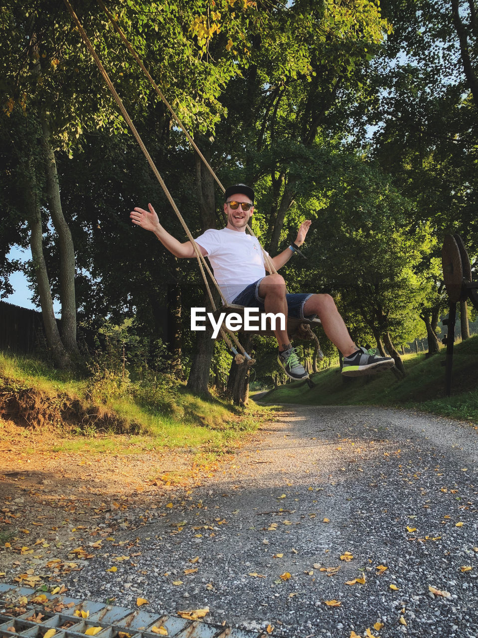 FULL LENGTH OF YOUNG MAN JUMPING ON TREES