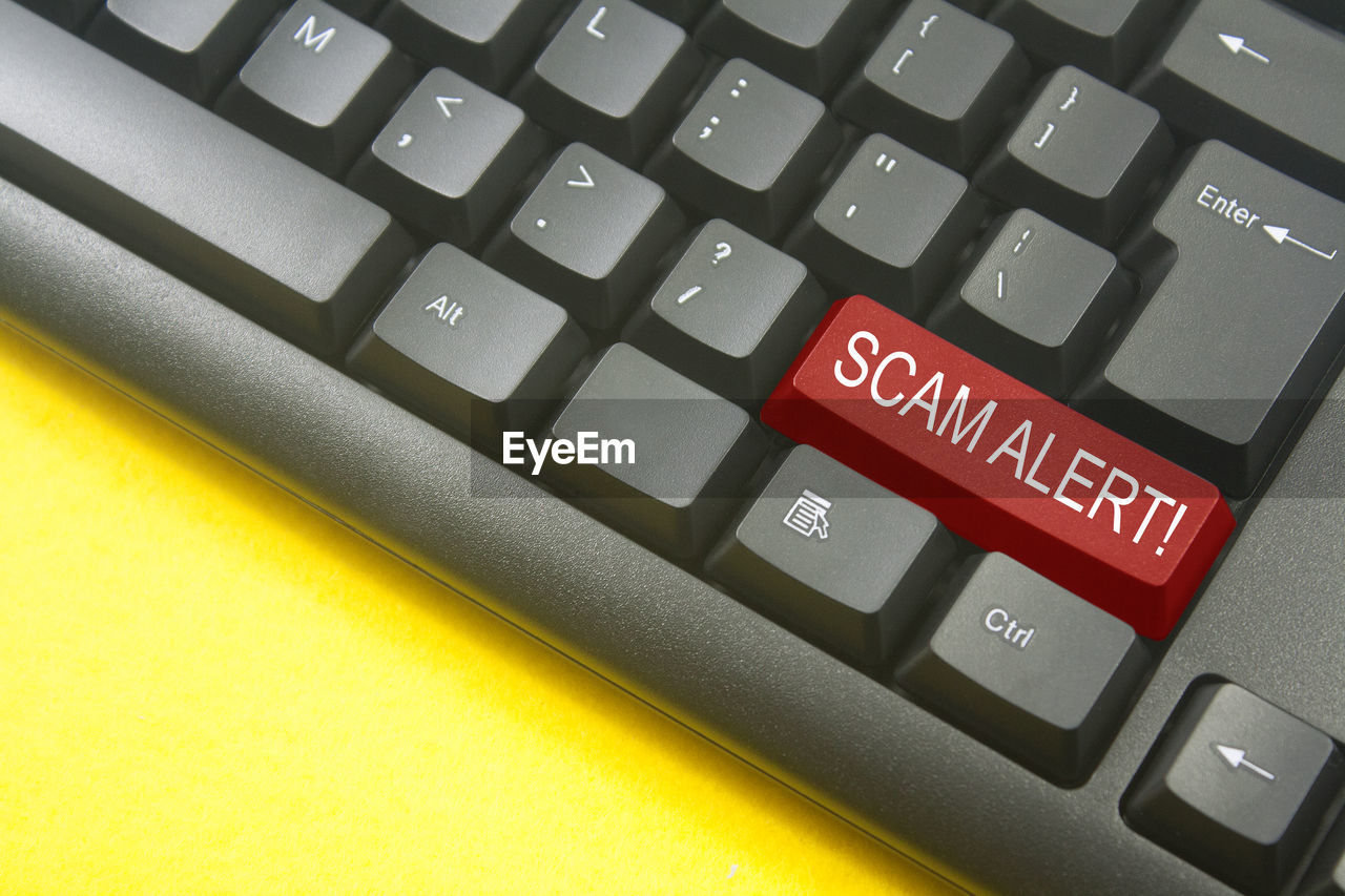 Close-up of scam alert text on computer keyboard