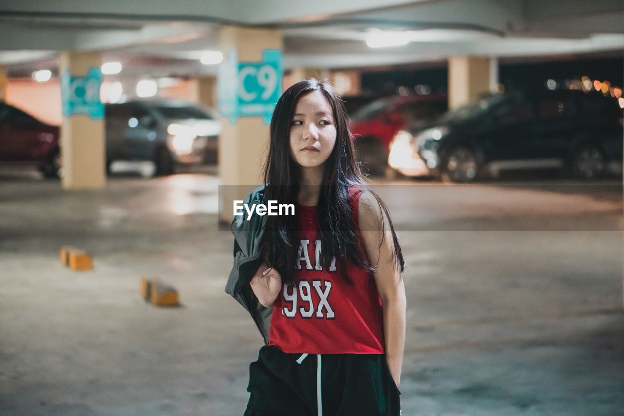 PORTRAIT OF YOUNG WOMAN STANDING IN BUS