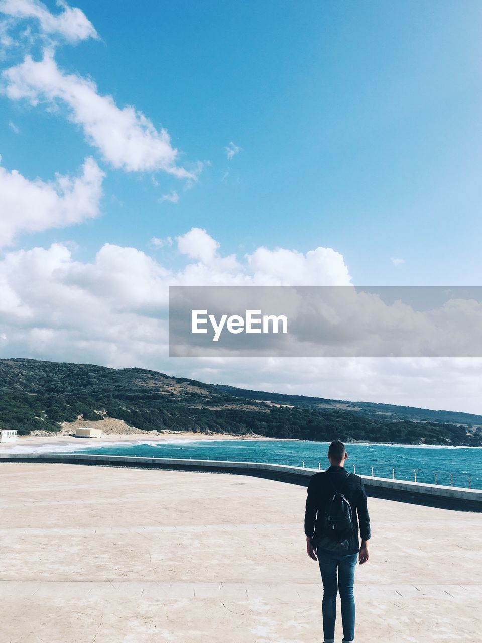 Rear view of man standing on promenade against sky