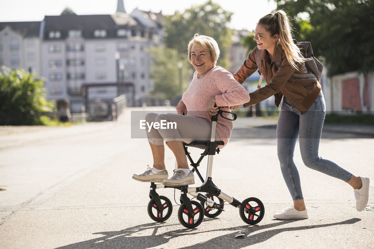 Granddaughter and her grandmother having fun with wheeled walker