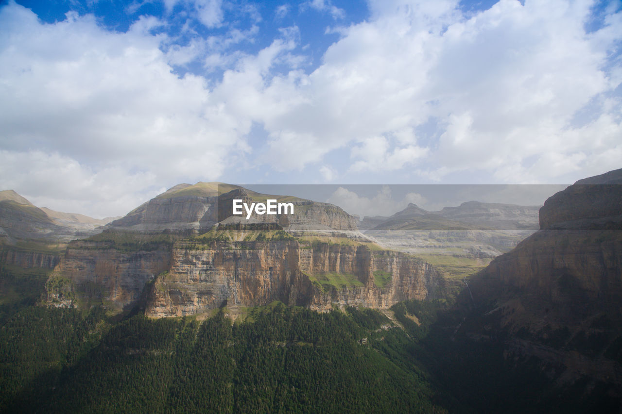 environment, sky, cloud, mountain, landscape, scenics - nature, nature, beauty in nature, land, travel destinations, travel, mountain range, tourism, no people, rock, tranquility, outdoors, non-urban scene, tranquil scene, plant, day, tree, terrain, plateau, valley, panoramic, cliff, trip, vacation, holiday