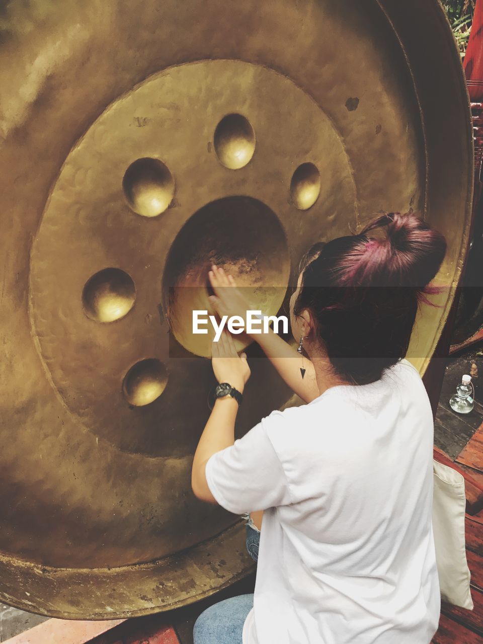 High angle view of woman touching metal