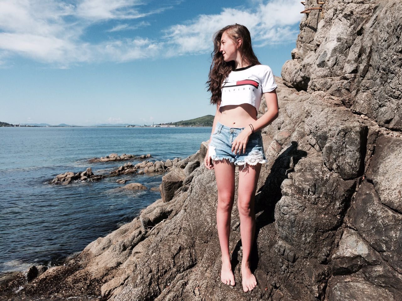 YOUNG WOMAN WITH HANDS ON BEACH