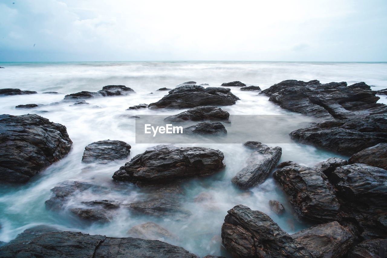 Scenic view of sea and rock against sky, lanta island thailand.