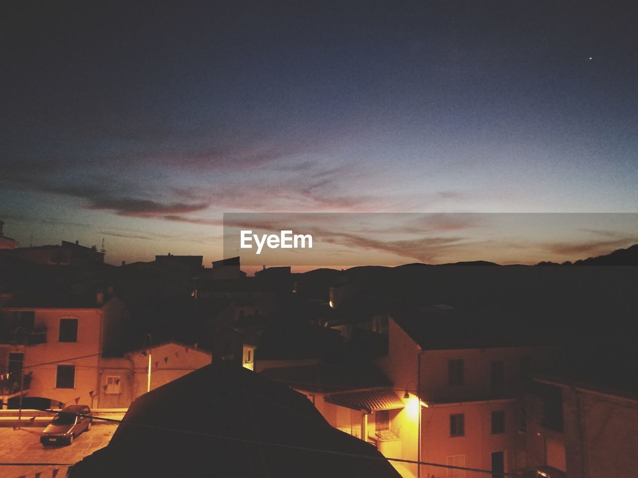 SILHOUETTE HOUSES AGAINST SKY AT SUNSET