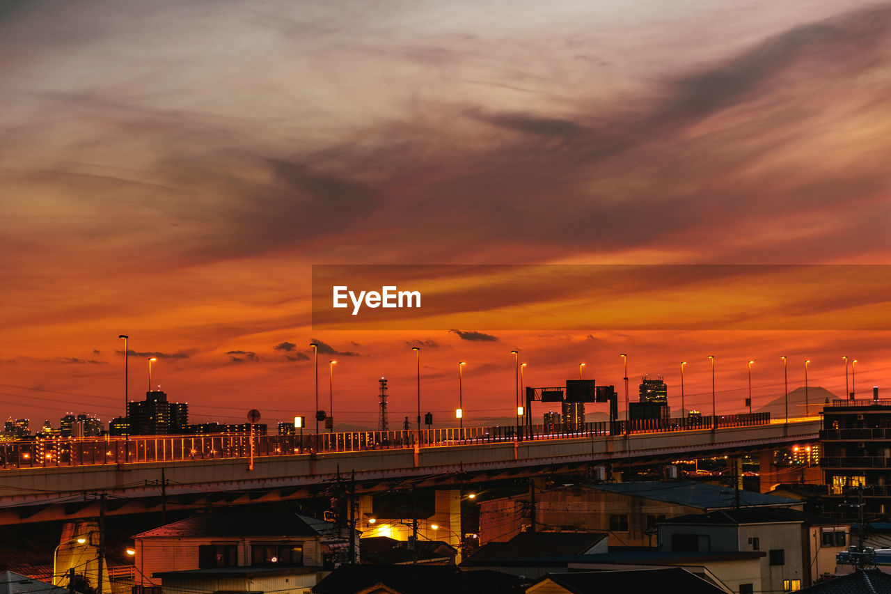 Illuminated bridge against sky during sunset