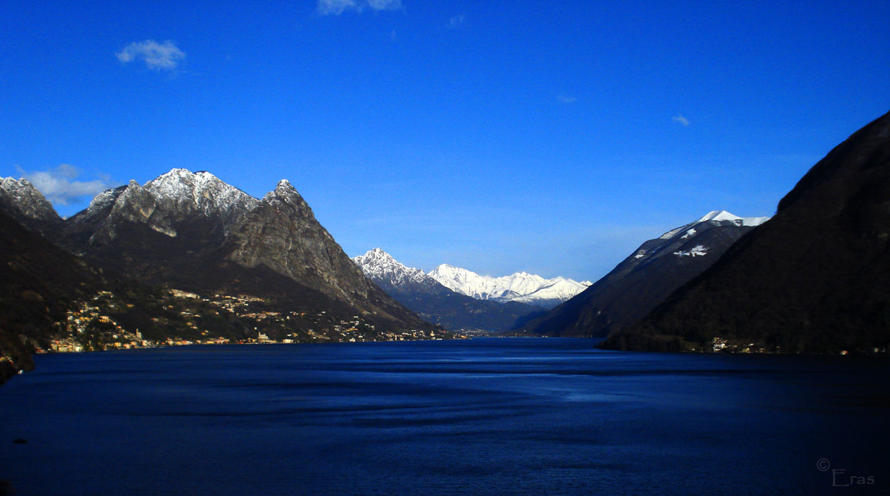 Scenic view of lake lugano by mountain against sky