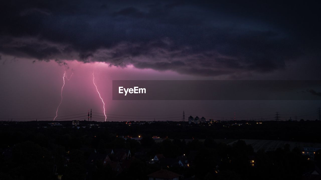 Scenic view of lightning over city at night