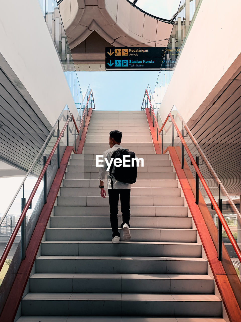 Rear view of man walking on staircase