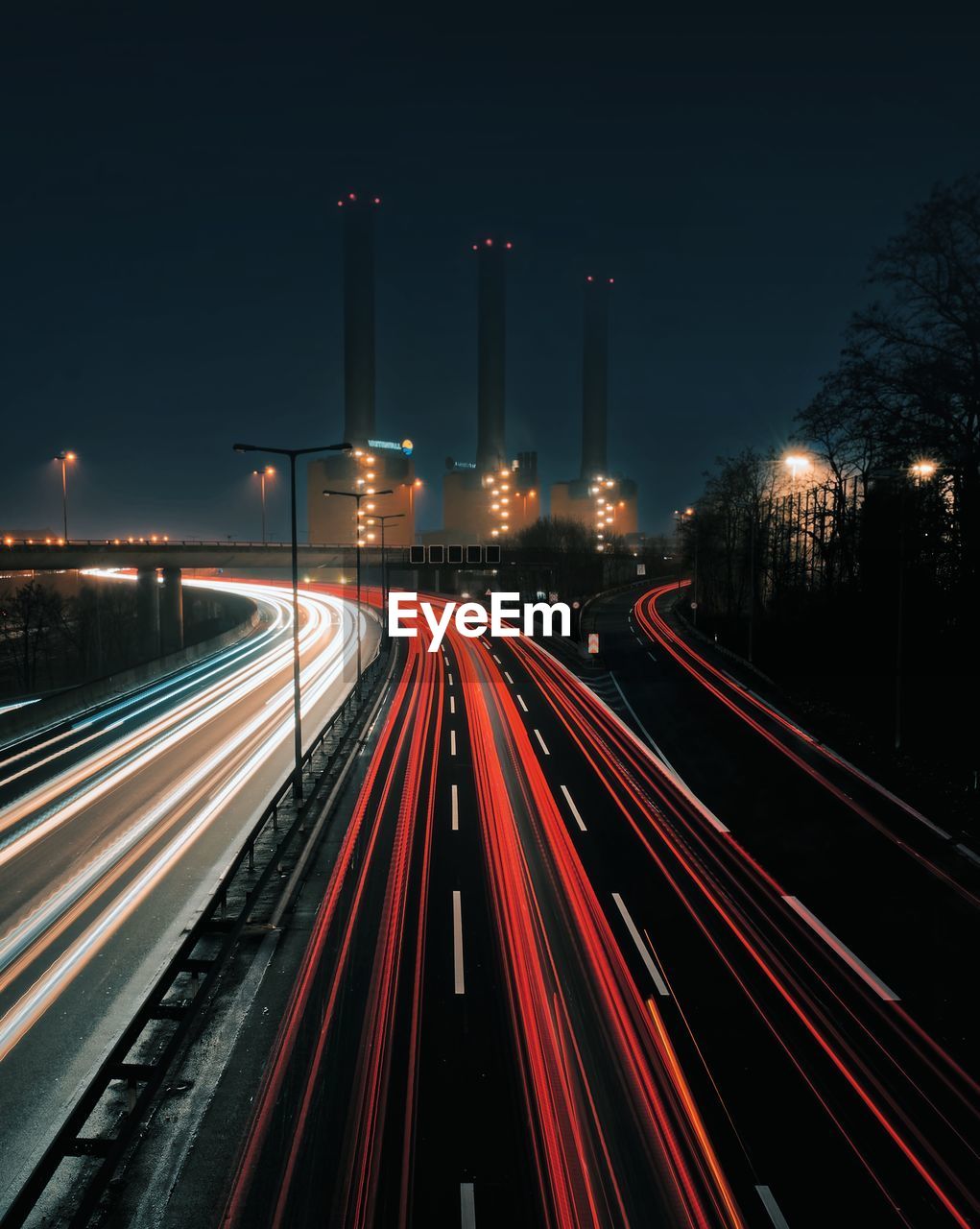 Light trails on road against sky at night