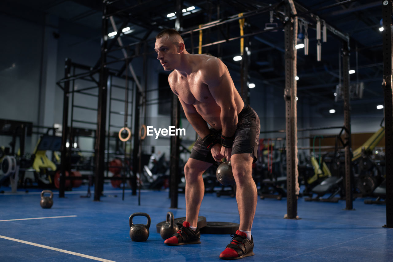 Muscular man exercising with kettlebell