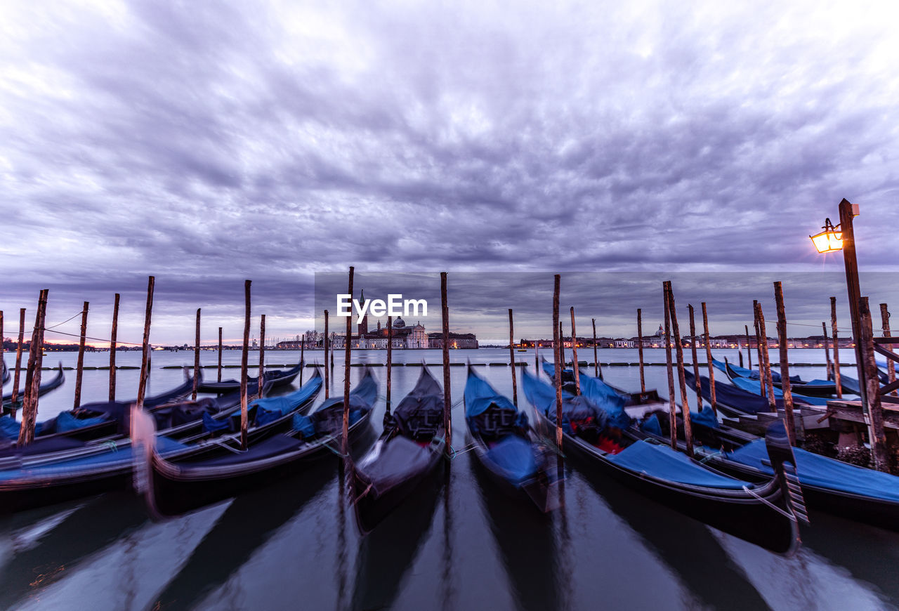 boats moored at harbor against sky