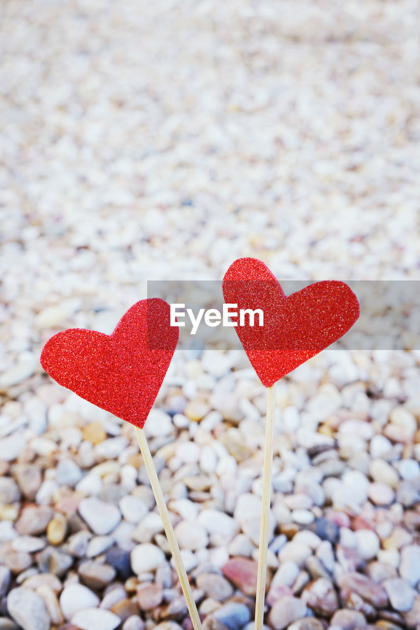 Close-up of red heart shape on pebbles