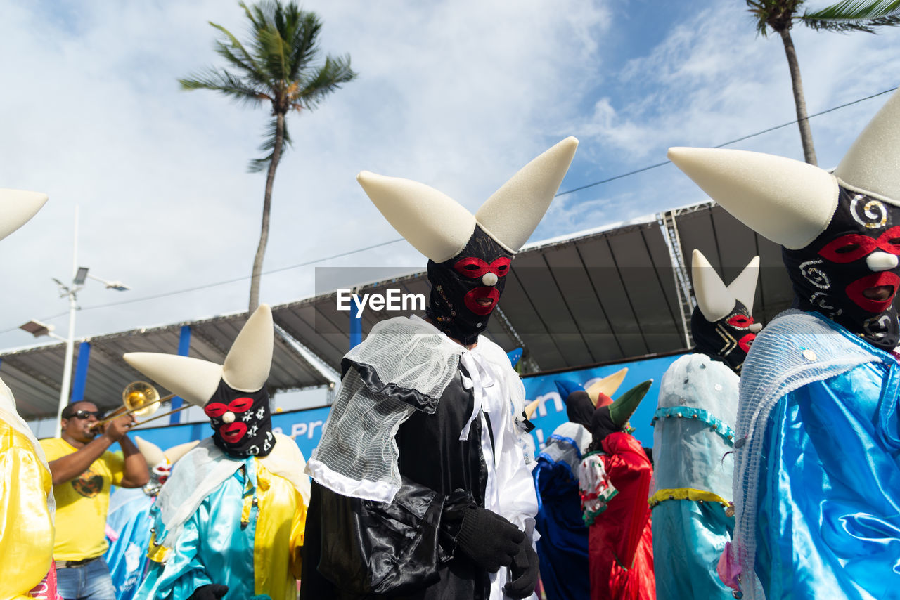Group of masked and costumed people parade in fuzue, pre-carnival in salvador, bahia, brazil.