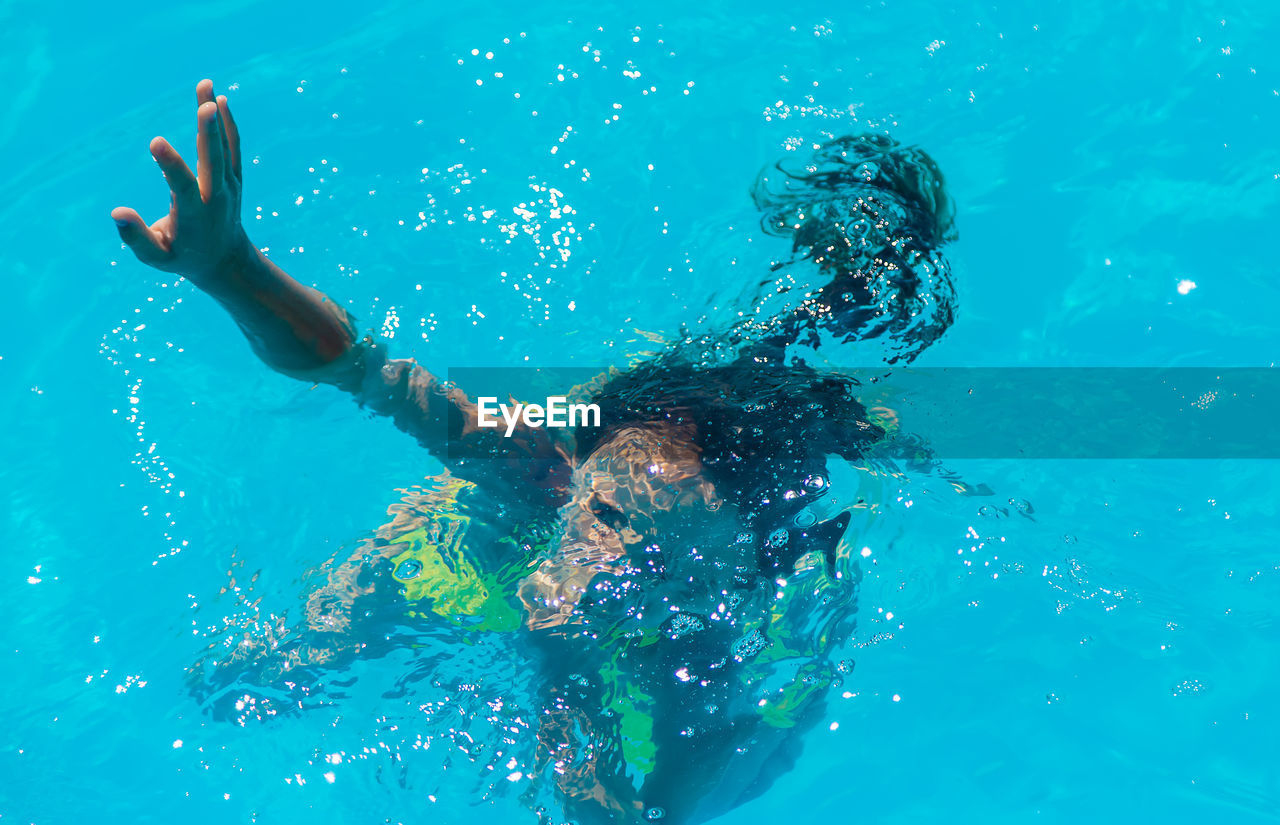 low section of woman swimming in pool