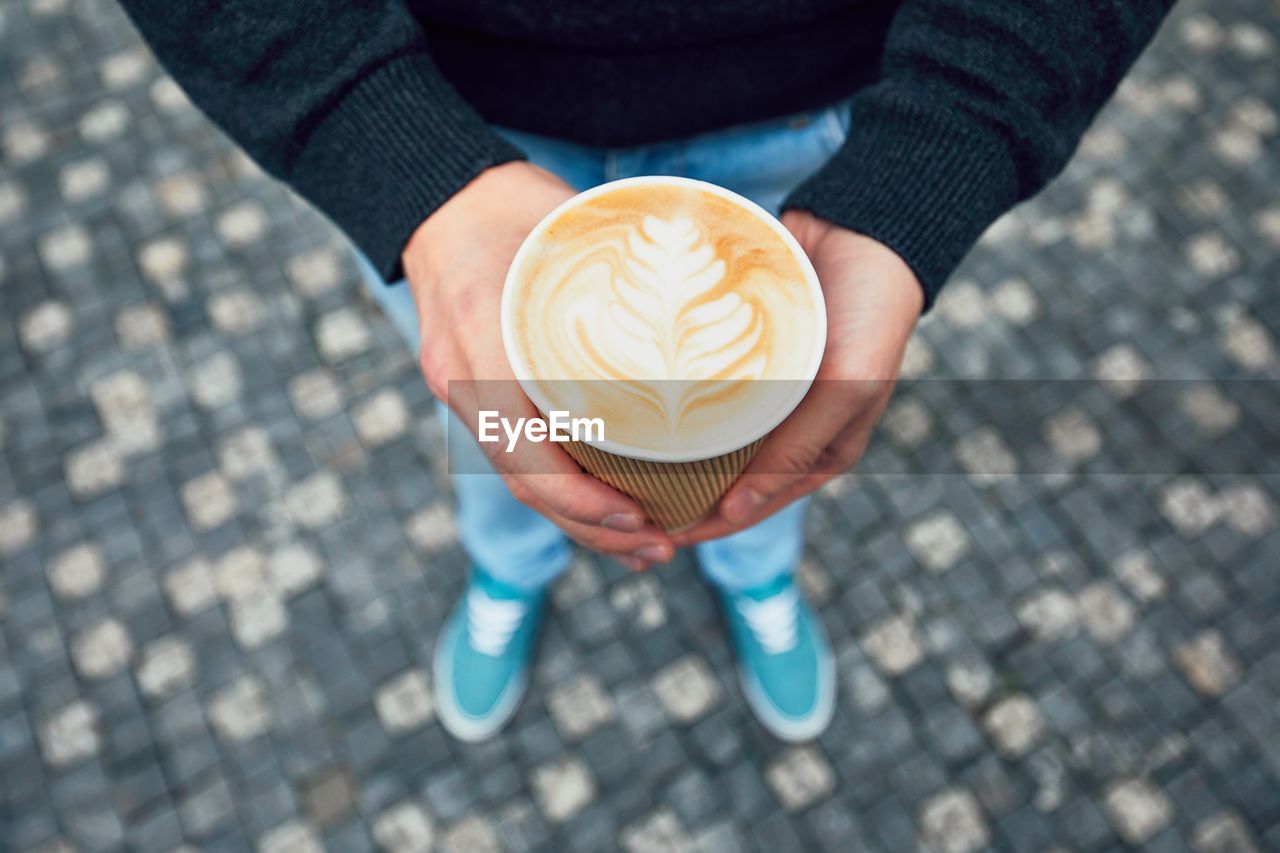 Low section of woman holding coffee in cup