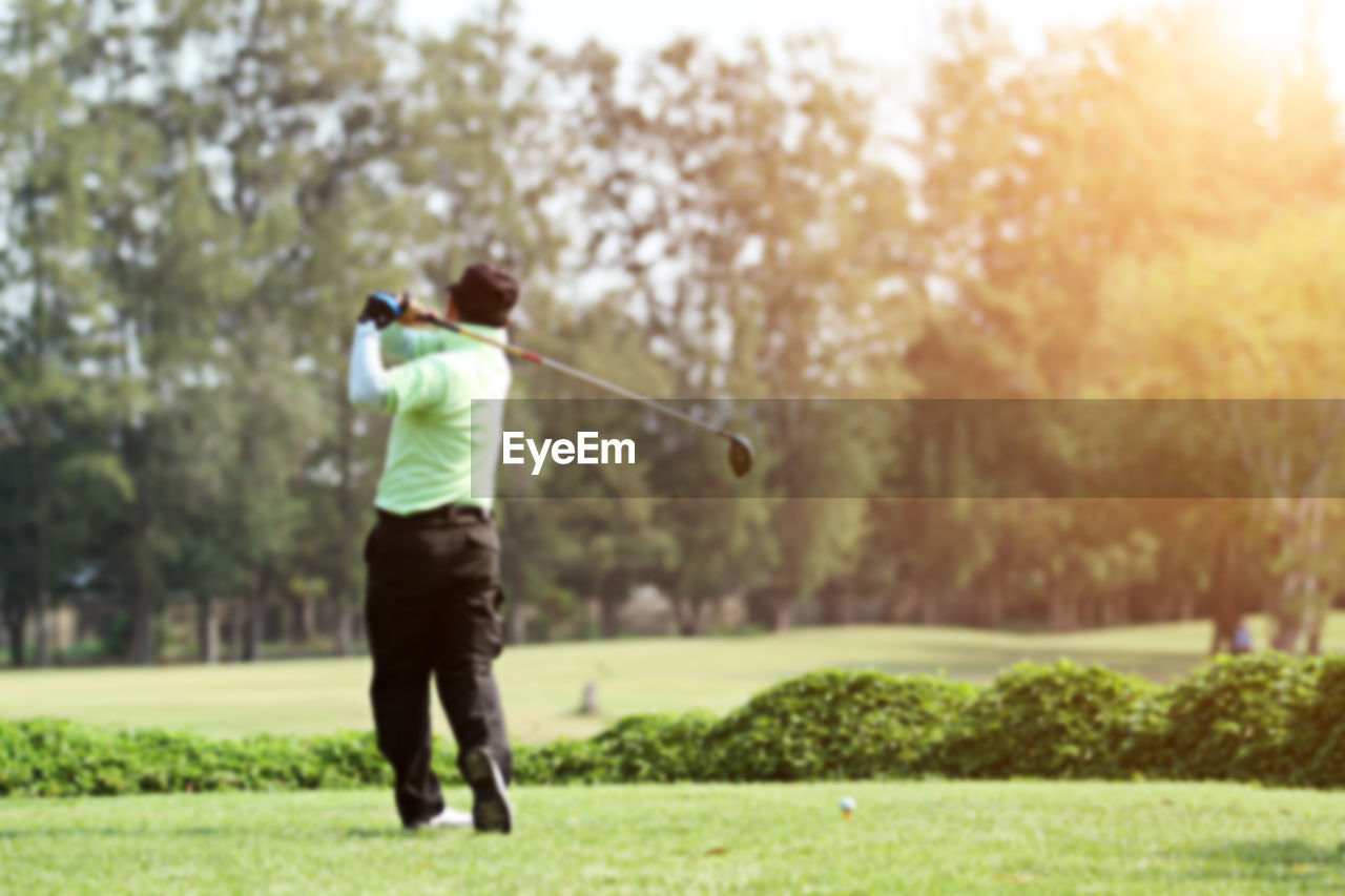 Rear view of man playing golf
