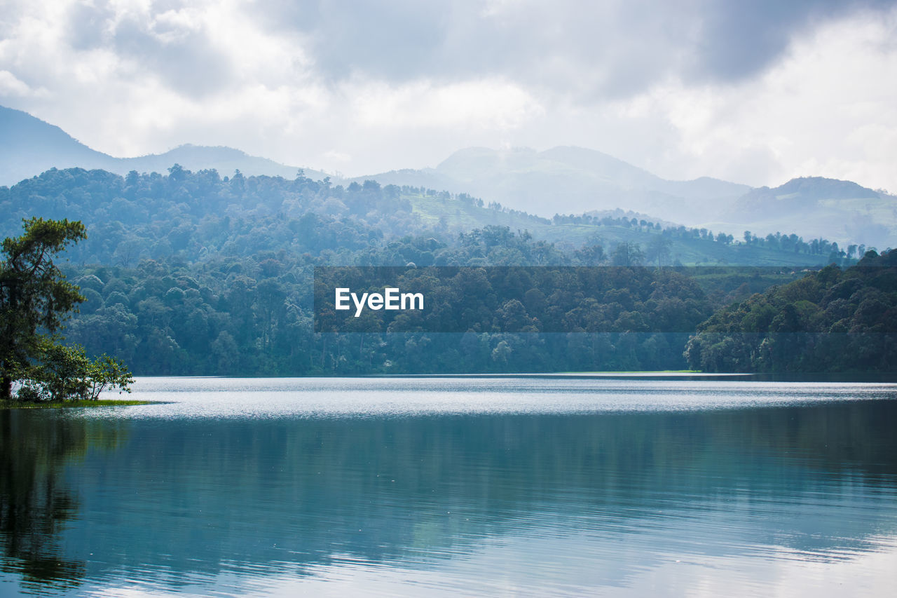 Scenic view of lake by mountains against sky