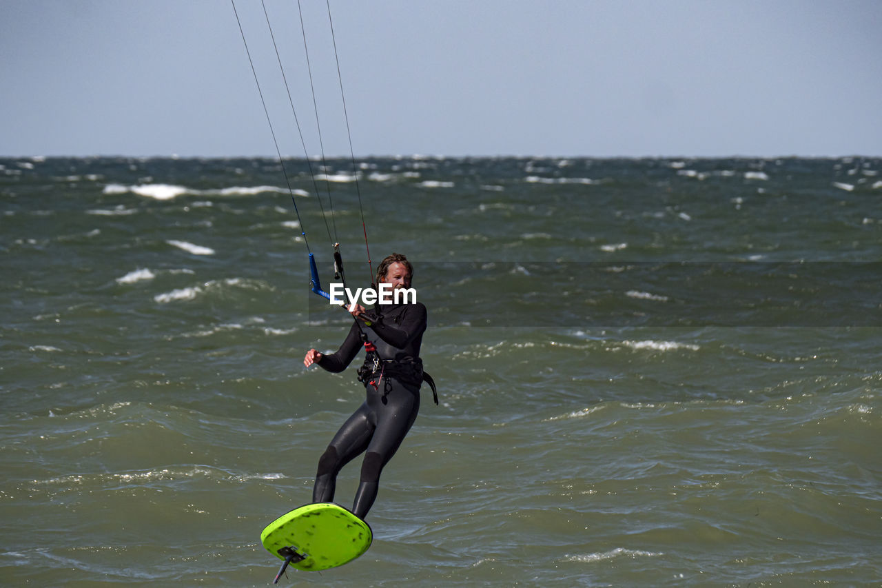 rear view of woman swimming in sea against sky